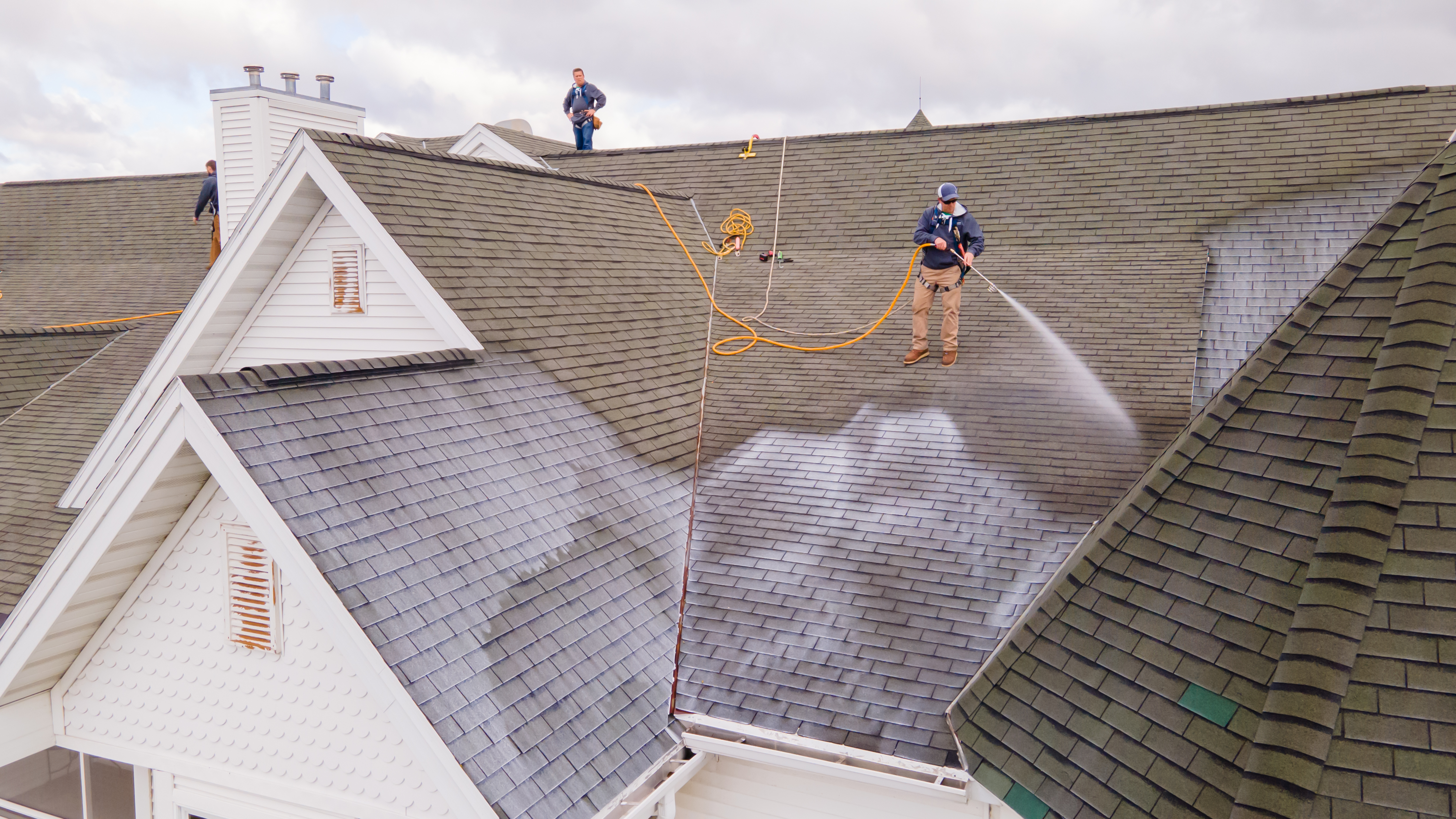 Roof Maxx technicians treating a large residential roof