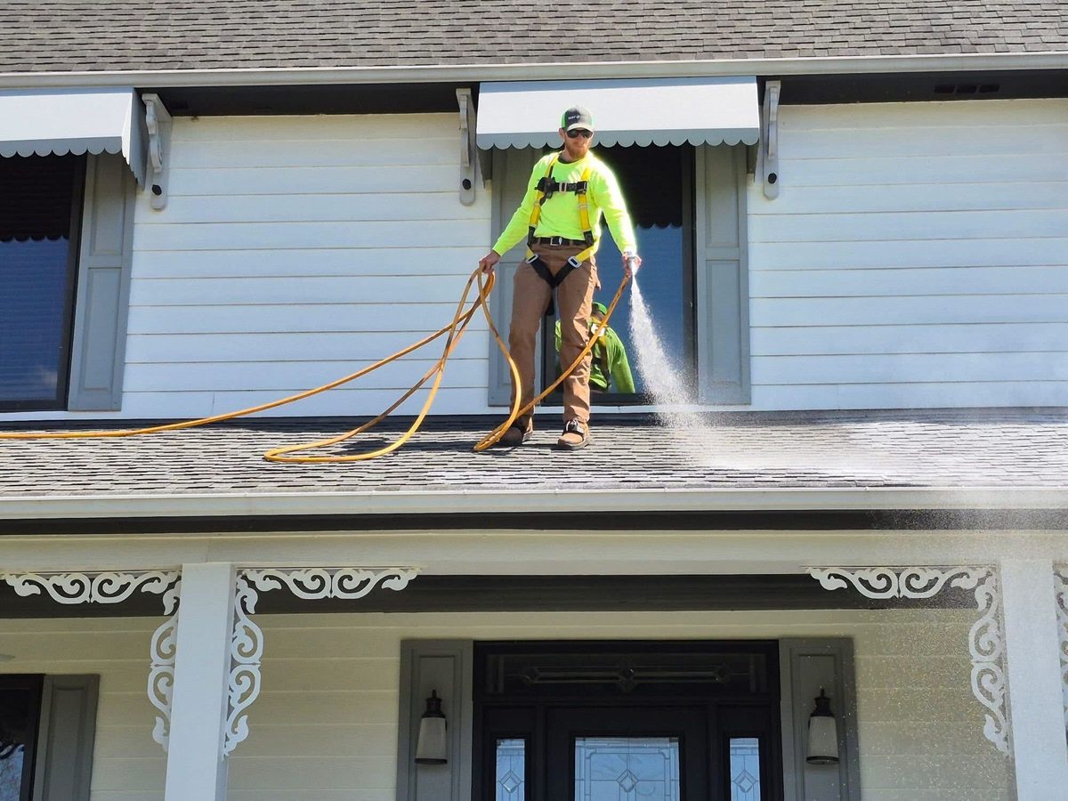 Roof Maxx technician spraying a residential roof